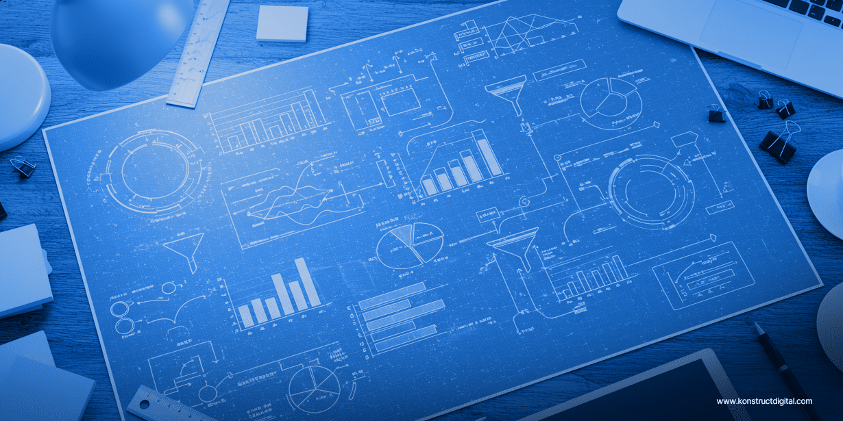 Overhead view of a blueprint-style poster on a wooden desk, displaying various white technical diagrams, graphs, bar charts, pie charts, data funnels, and flowcharts.