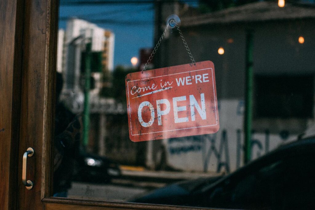 An open sign hanging on the door of a business