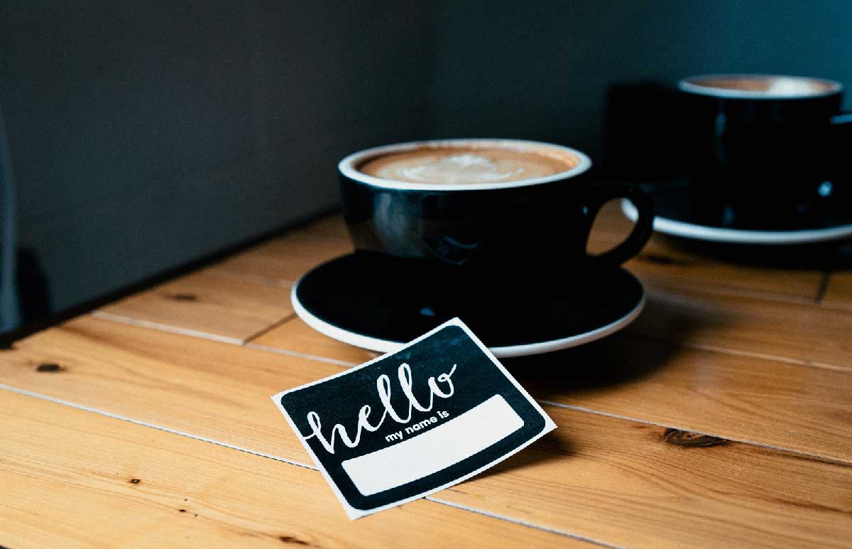 Name Tag Next to a Cup of Coffee