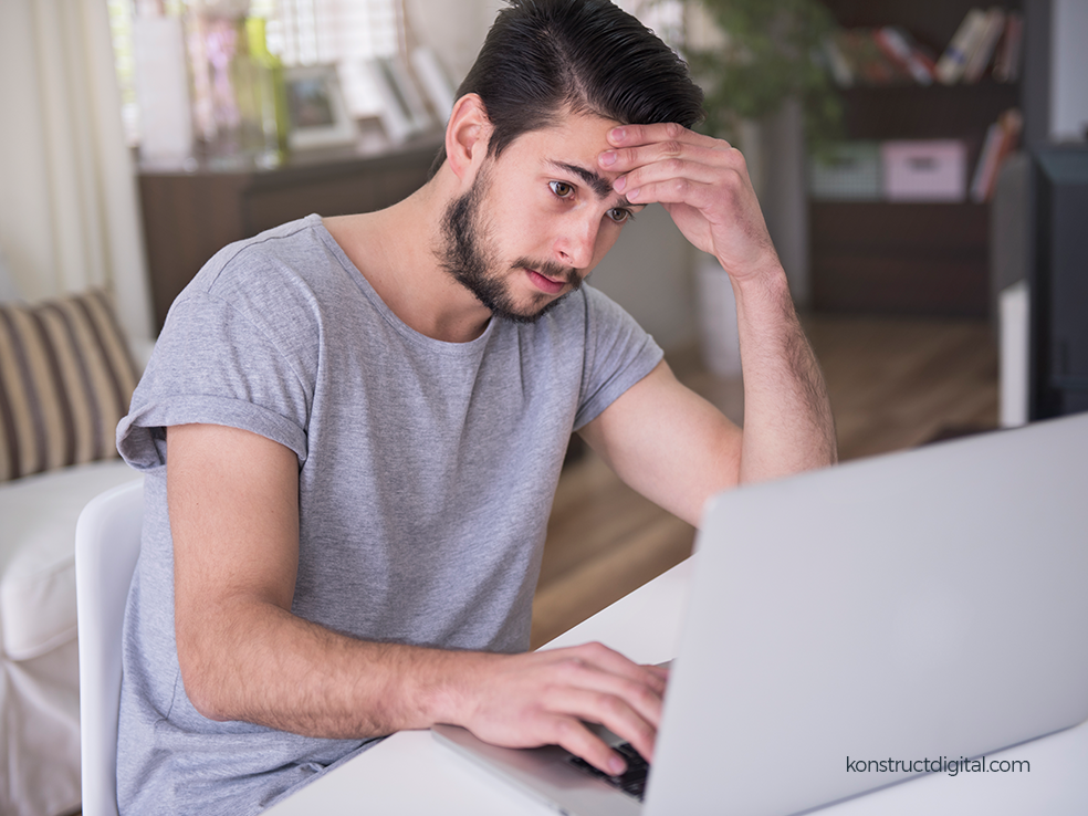 A stressed person looking at a laptop