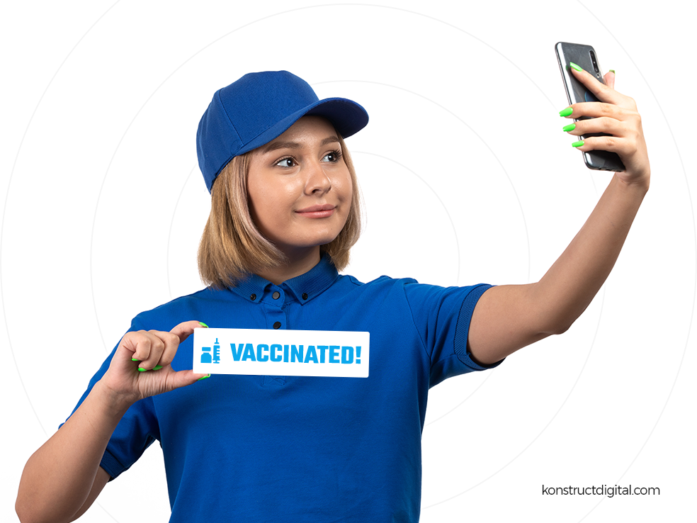 A girl taking a selfie with a vaccination card.