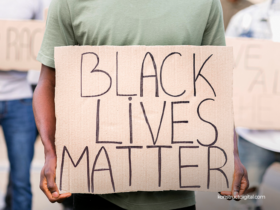 A man holding a "Black Lives Matter" sign