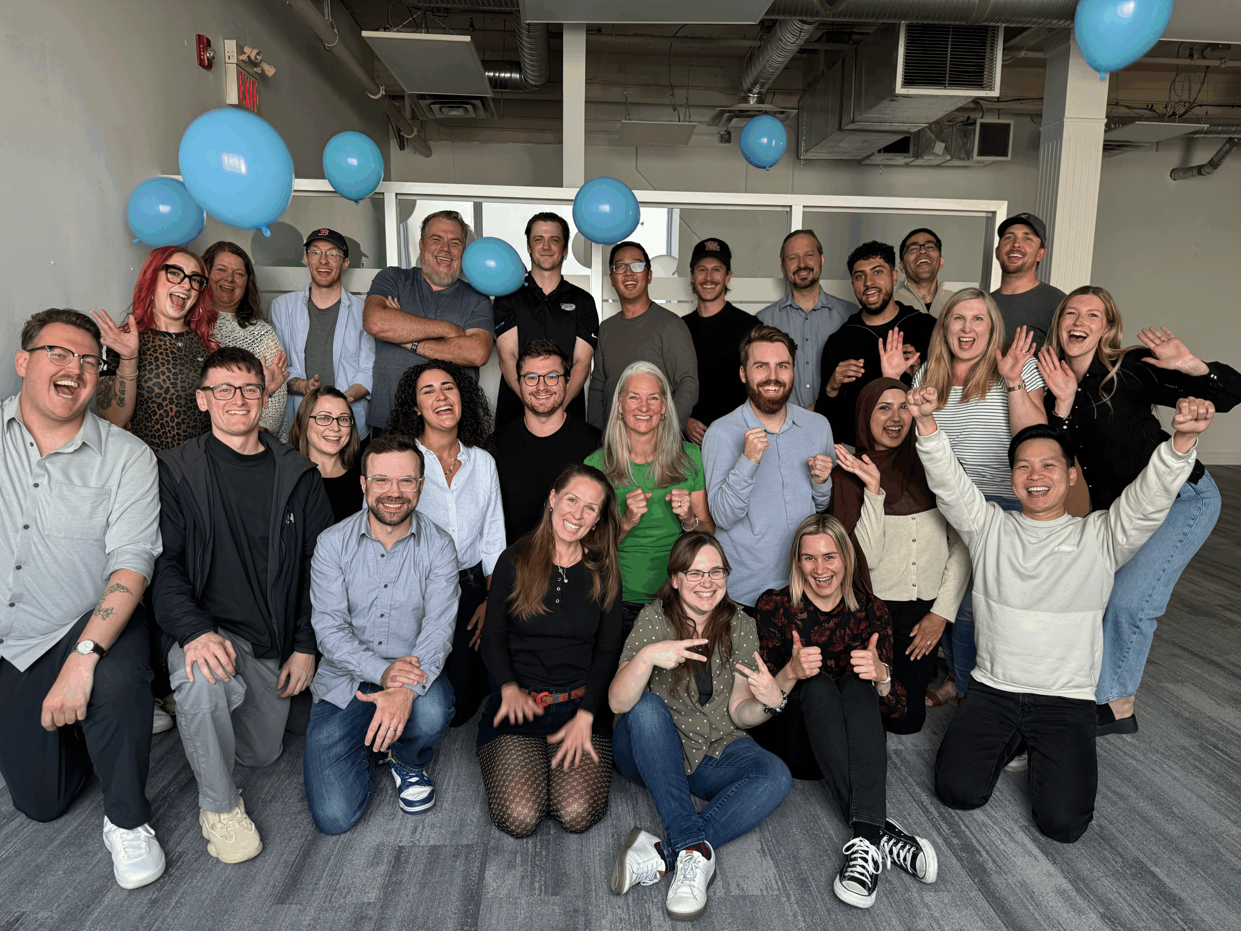 Konstruct team throwing balloons in the air