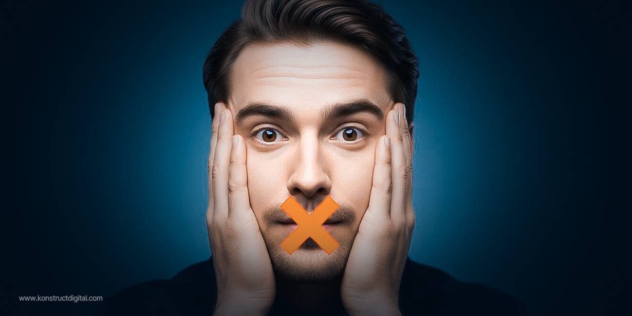 Close-up of a surprised man holding his face with an orange X over his mouth, symbolizing banned marketing buzzwords
